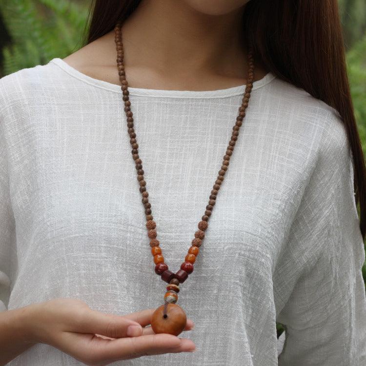 Woman wearing a natural wood and Rudraksha bead mala necklace, perfect for meditation and grounding practices